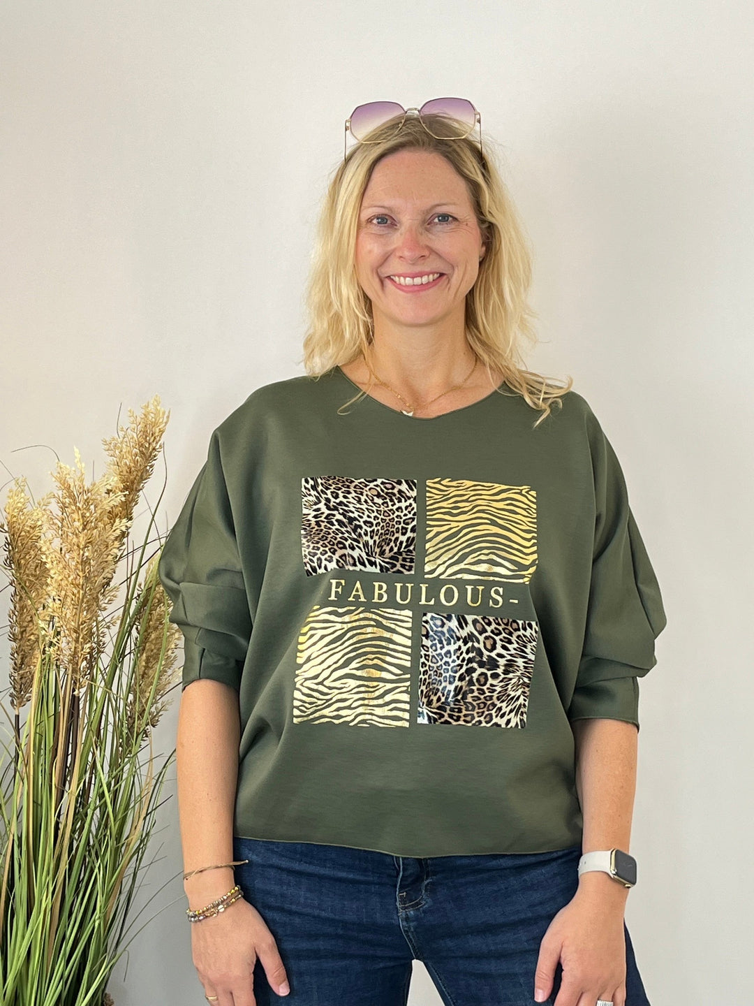 Olivgrüner Pullover mit hochgekrempelten Ärmeln