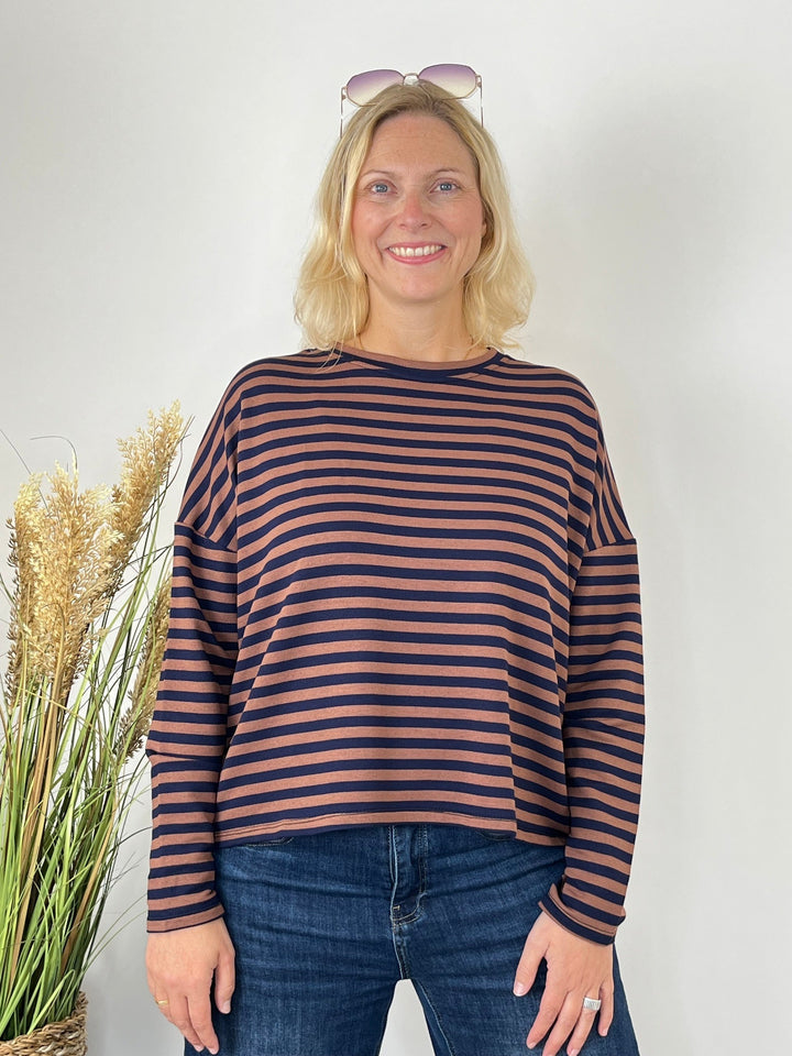 Frontalansicht des Streifensweaters in Braun- und Blautönen mit Sonnenbrille