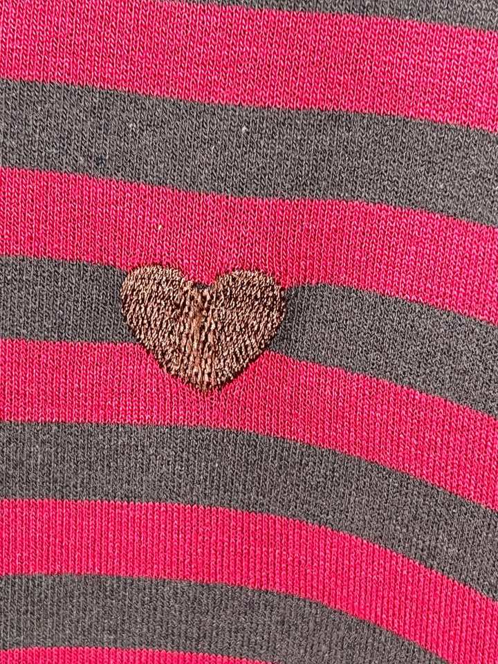 Nahaufnahme der Streifenmusterung und Herzstickerei am Sweater