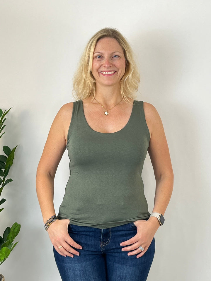 Olivgrünes ärmelloses Top mit Rundhals, lächelnde Frau in Jeans