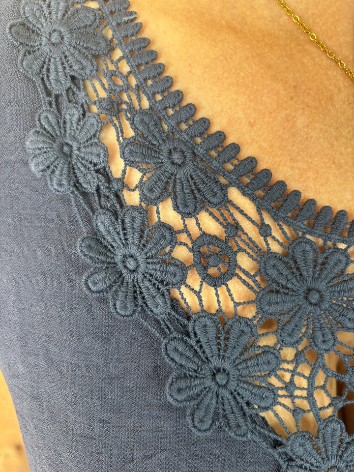 Detail Nahaufnahme floraler Spitze am V-Ausschnitt marine Top