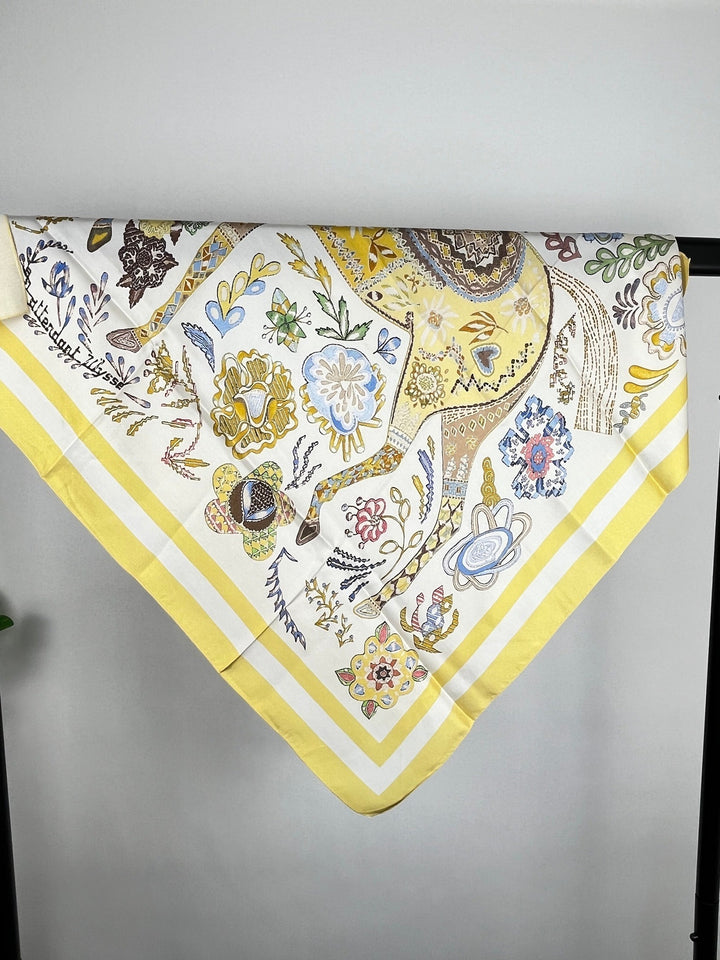Flachliegendes Vierecktuch mit Tiermotiv und gelbem Randstreifen im Ornament-Stil
