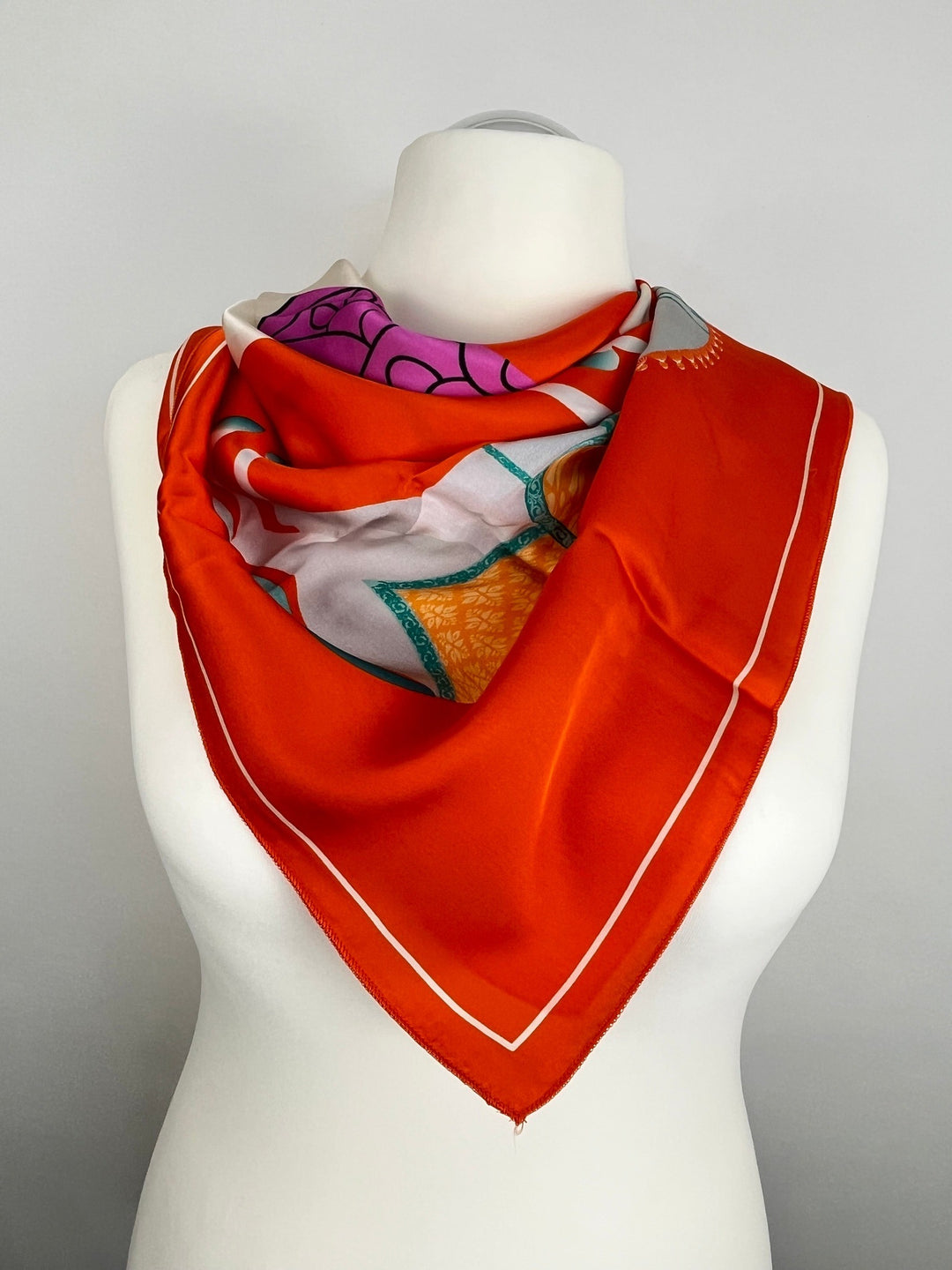 Oranges Seidentuch mit Blumenmotiv und Türkisakzent um Hals