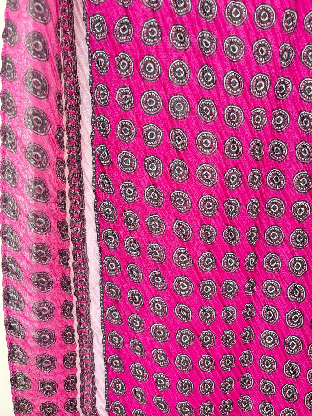 Nahaufnahme: Pinker Viskoseschal mit Crinkle-Struktur und grafischem Muster