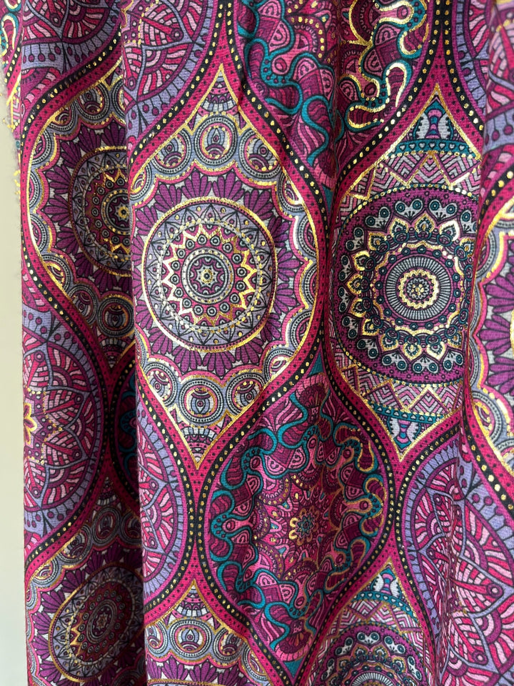 Nahaufnahme Schalstoff symmetrisches Mandala in Magenta mit Goldverzierungen