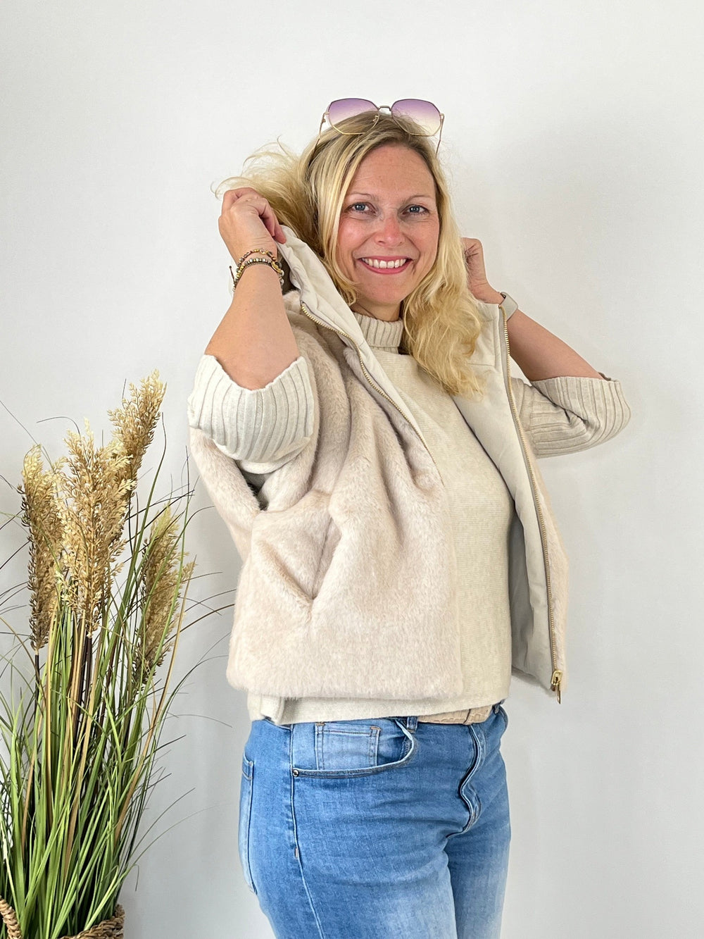 Wendeweste mit Fellimitat außen getragen über Strickpullover und Jeans