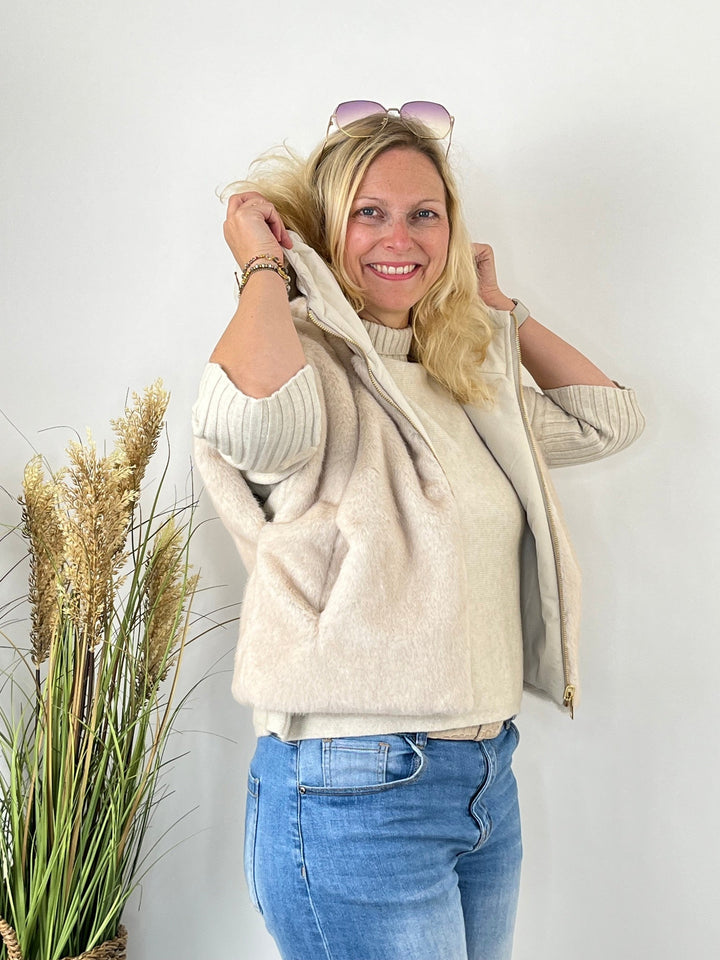 Wendeweste mit Fellimitat außen getragen über Strickpullover und Jeans