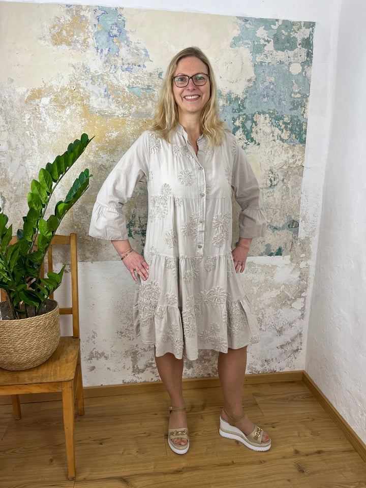Kleid mit ausgestelltem Arm und floraler Applikation